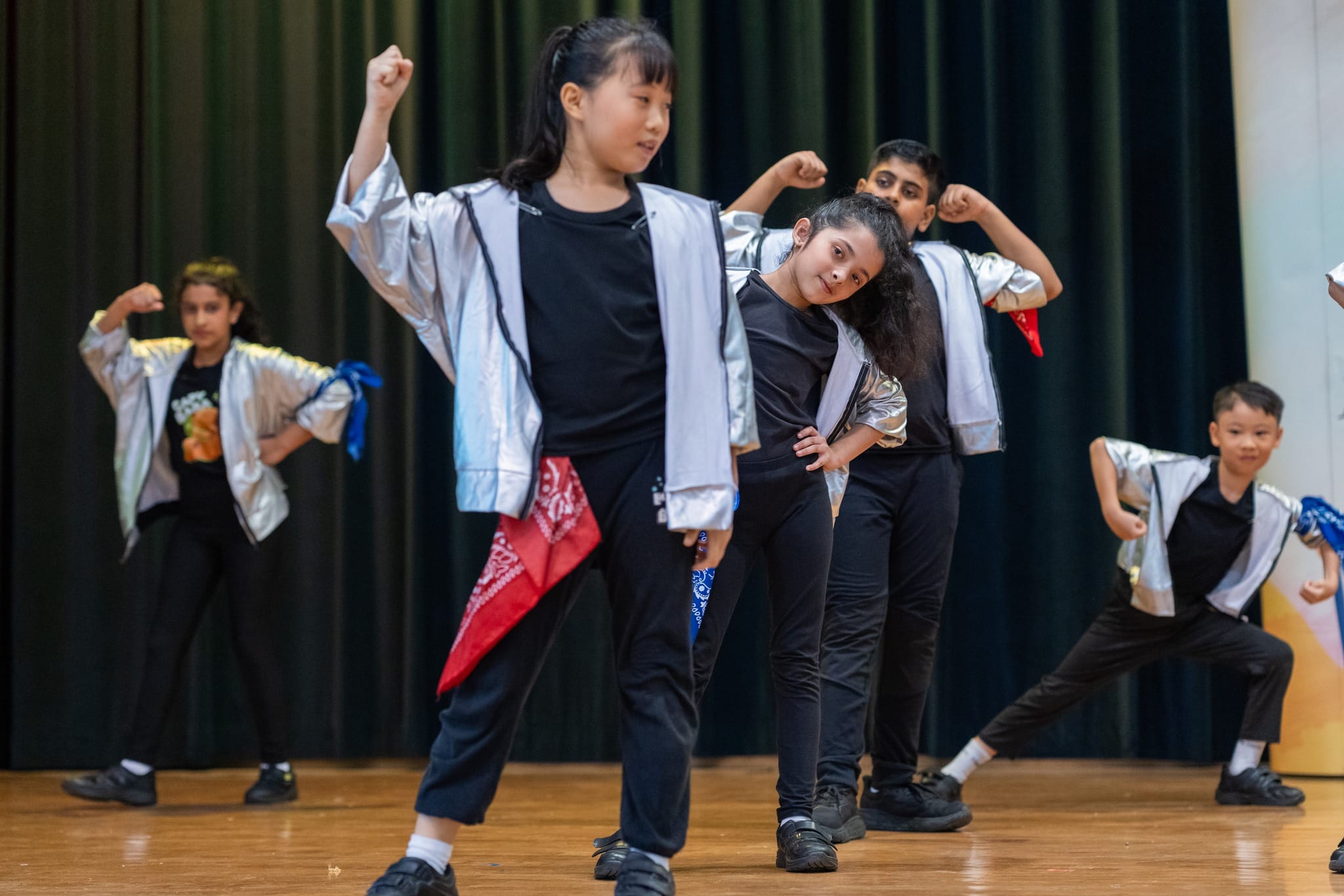 5 dancers practicing a performance routine on stage